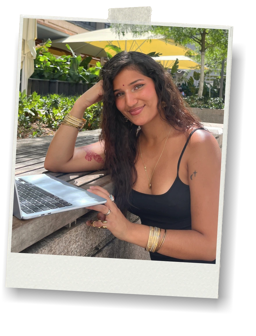 Tanvi sitzt mit Laptop an einem Tisch