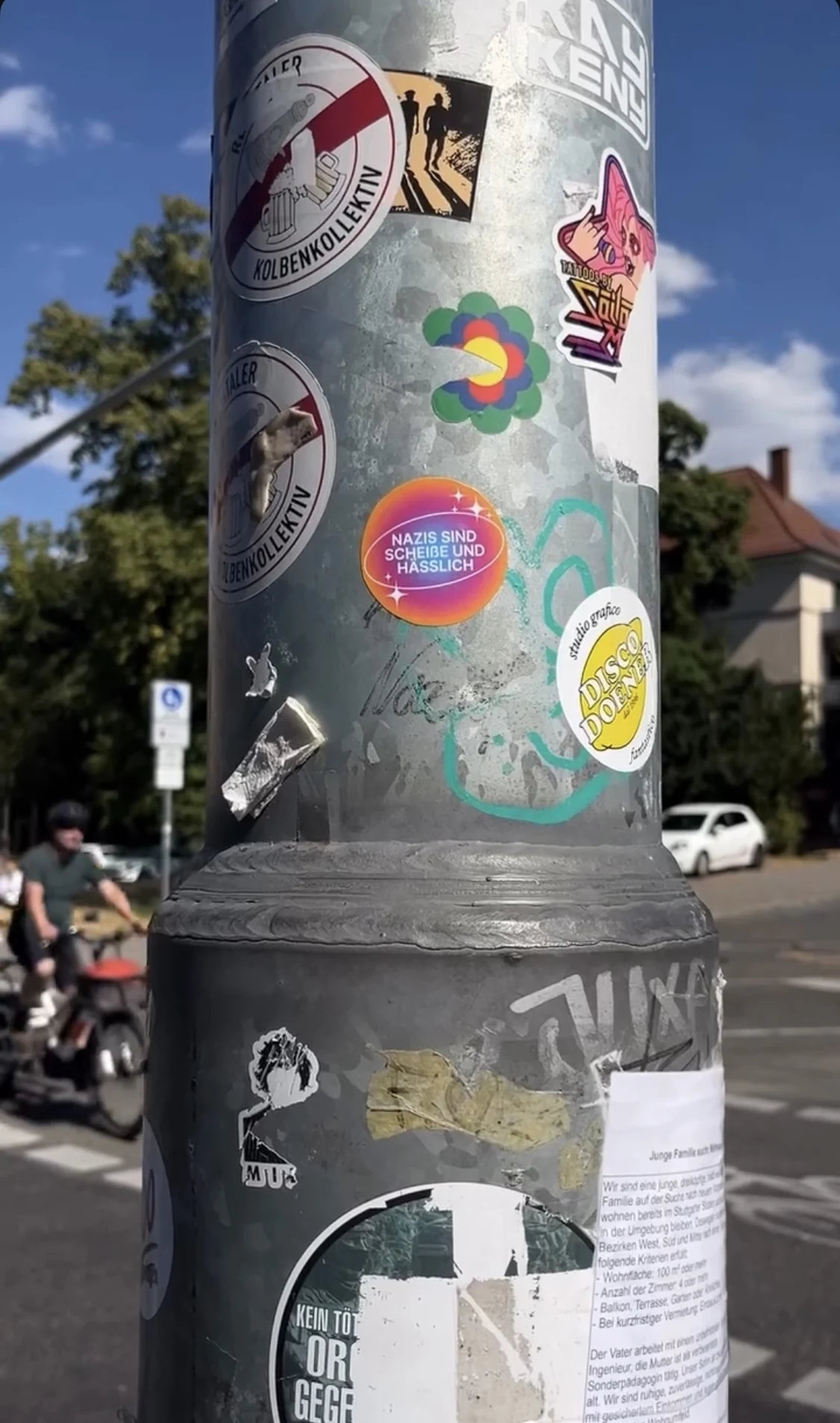 Sticker an einer Laterne im Stadtraum